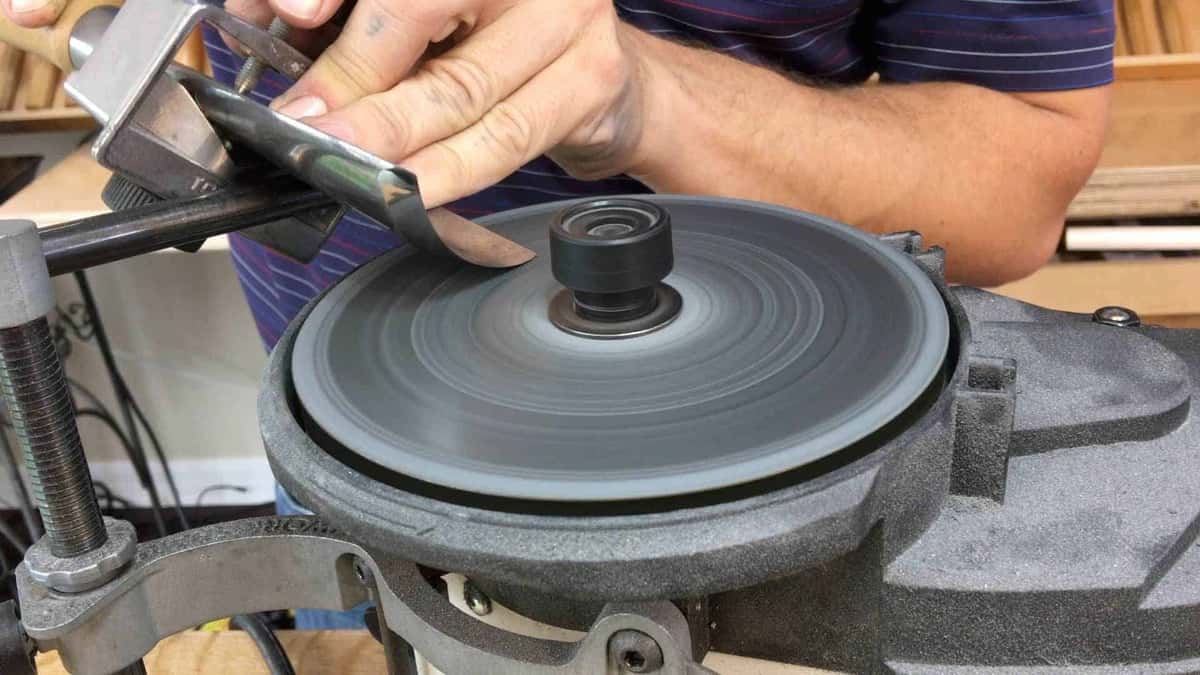 Sharpening a large gouge on a water fed grinding wheel, with the wet stone turning under both steady hands