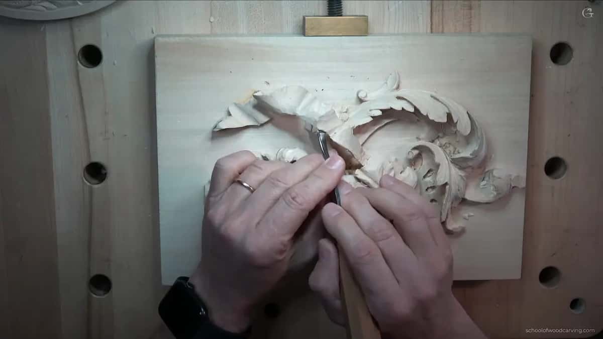 Steel buried in the carving with the handle held well clear of the surface behind it.