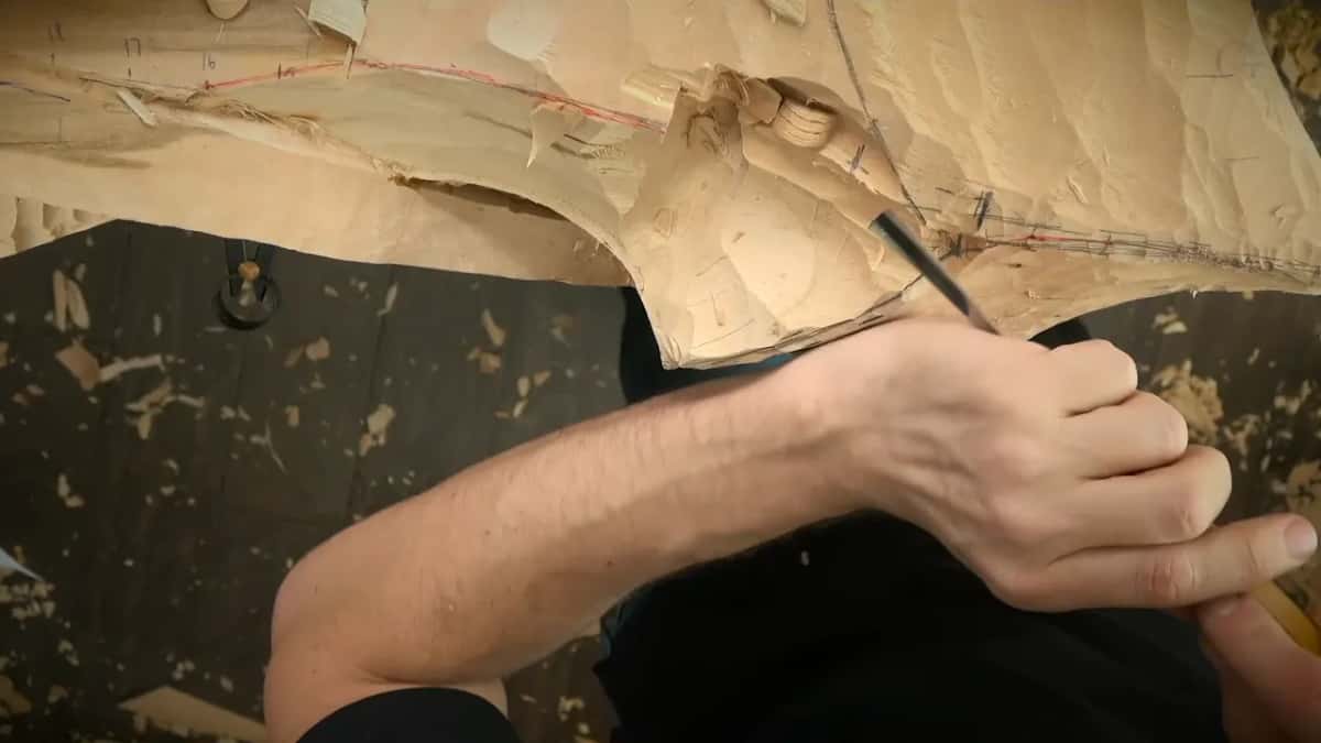 Right hand steering a gouge along pencil lines