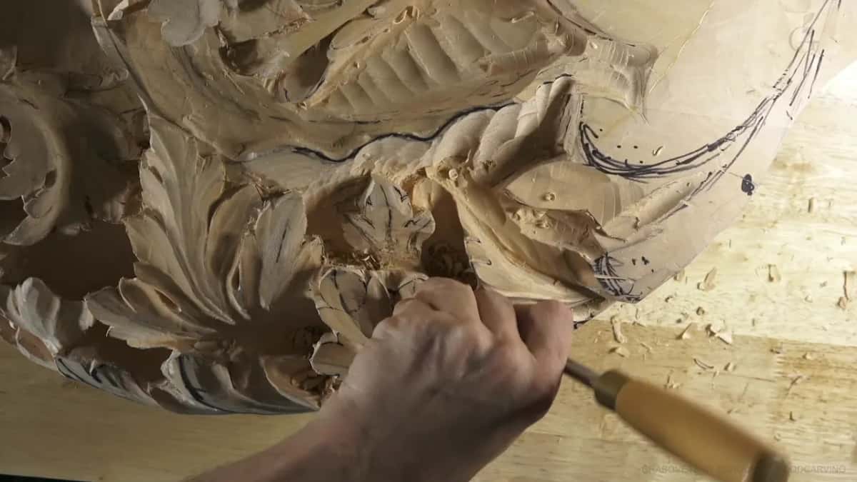 Another gouge goes in at an angle, its pale handle pointing down toward the bench.