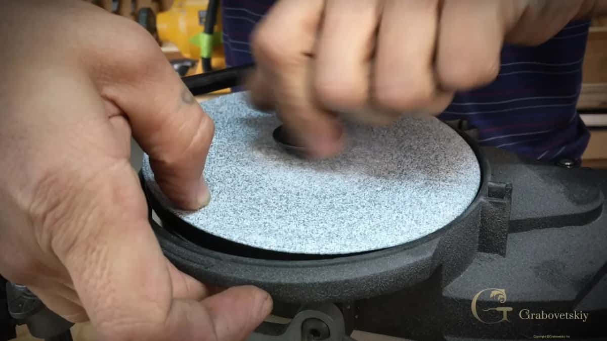 Lifting a fine disc off the platen to turn it over.