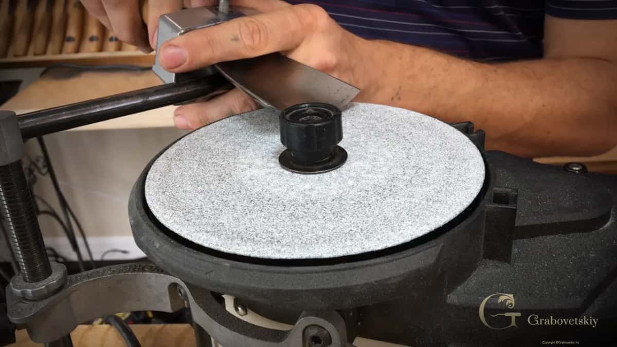 Jig resting on its support bar with the blade angled down onto the wheel.