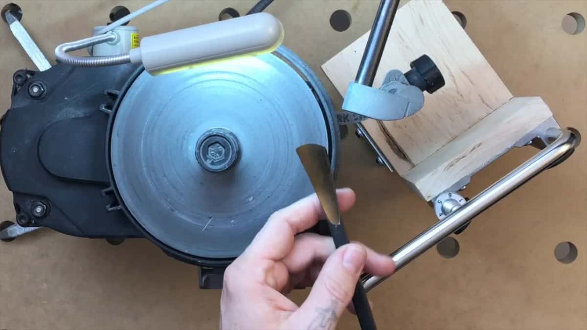 The tool held up, its edge running at a slant across the sweep.