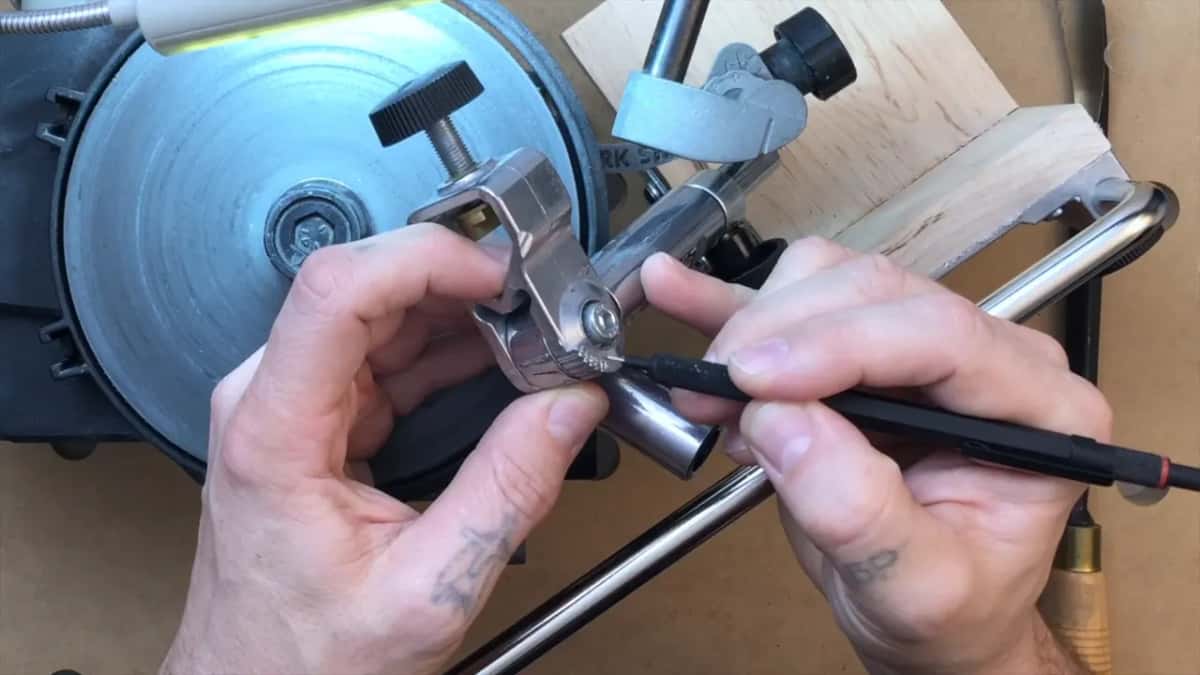 Serrated scale on the jig body, the tool seated and the clamp about to close.