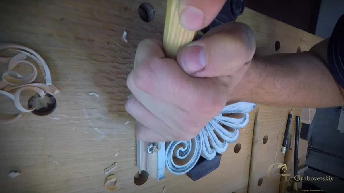 Fist wrapped around a gouge handle, pushing down
