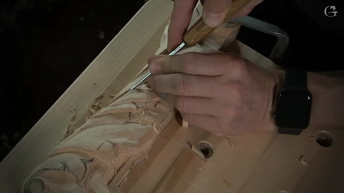Slim tool pinched between thumb and fingers, close to the edge