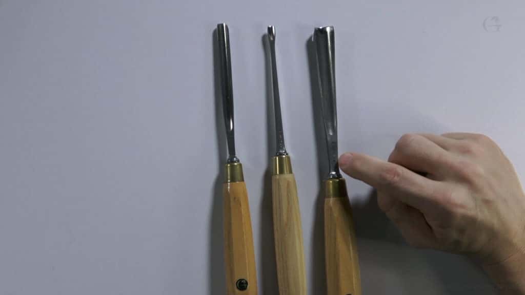 Three carving gouges side by side showing a straight gouge, a small veiner and a fishtail shape