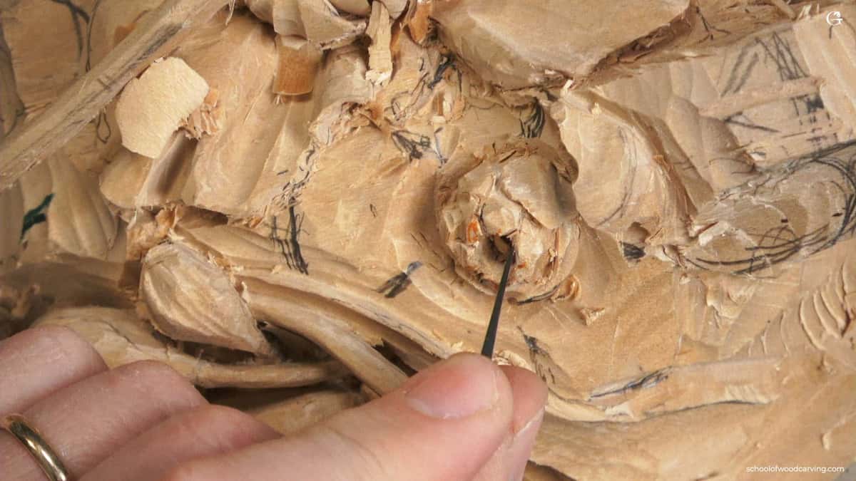 Close-up shot of a wood carving project, showing a skilled hand using a detail tool on soft wood. The intricate patterns and textures highlight the care involved in wood carving. This image represents the artistry found in wood carving classes and lessons, where enthusiasts learn to create beautiful pieces.