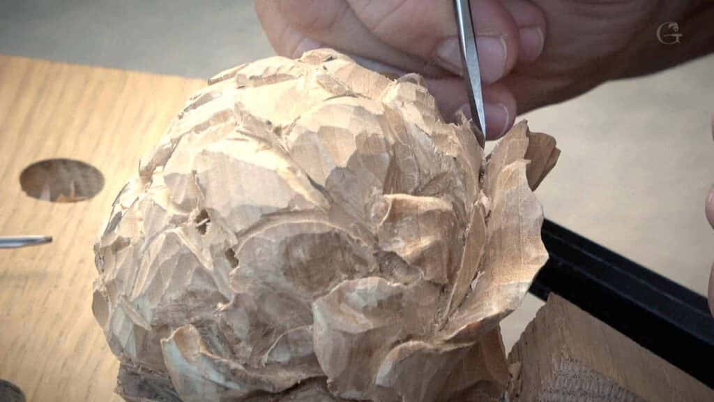 Flower rosette carved in pale basswood on a workbench