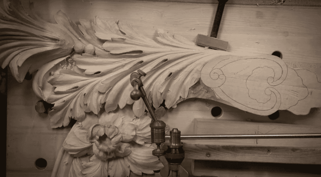 Deep relief carving held by clamps while a pointing machine guides the cuts