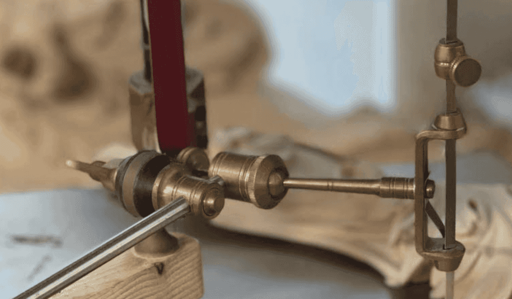 Antique pointing machine with brass arms on a wood base, the design used since about 1800