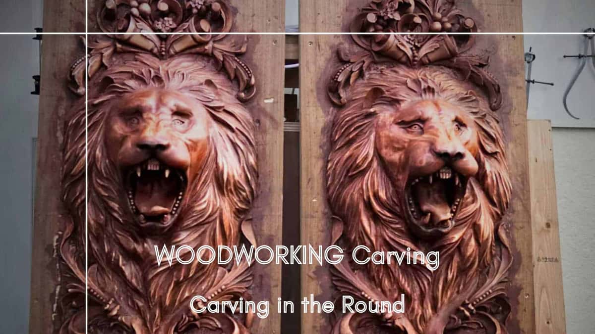 Two carved lion head panels finished in a deep red brown colour, mounted on boards and clamped upright in the workshop