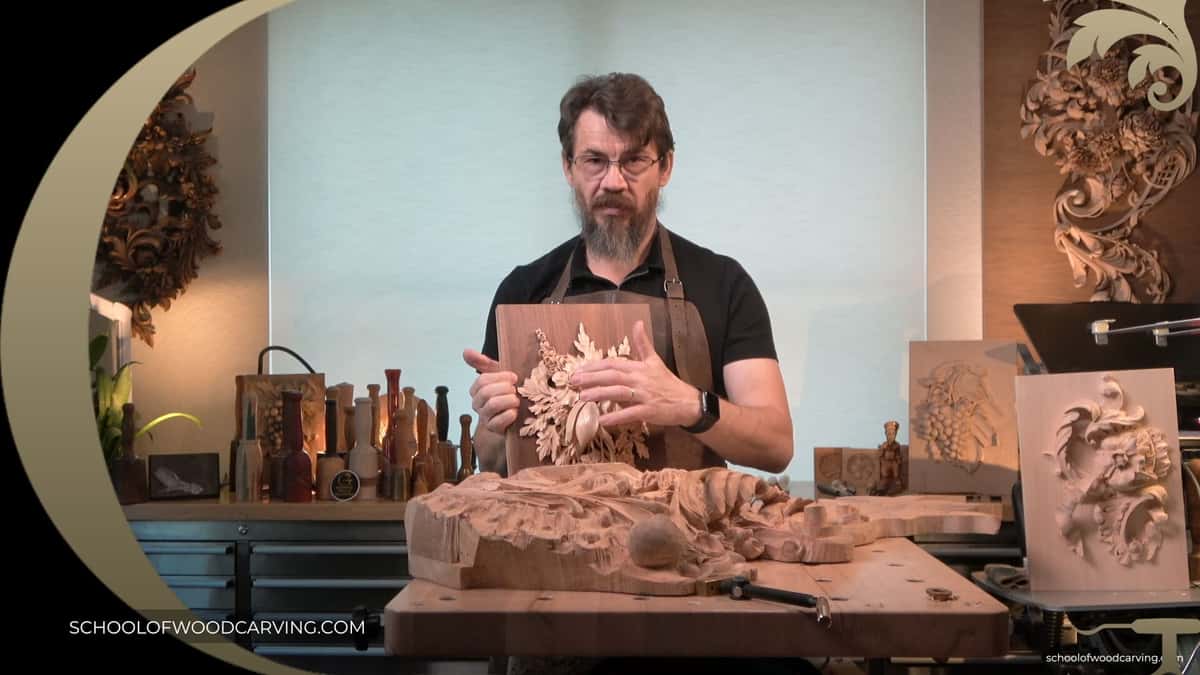 A man in Grinling Gibbons style is carving a piece of wood.