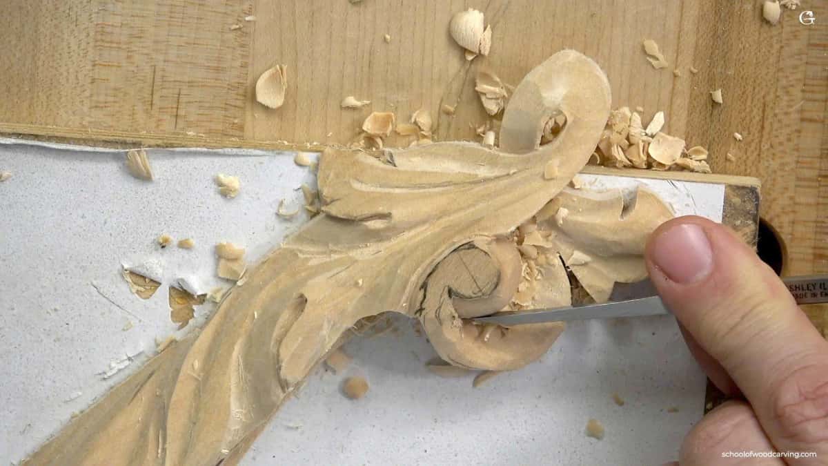 Knife work where a leaf turns over a molding edge A thin blade slicing at the eye of an acanthus scroll where the leaf rolls over the edge of the molding