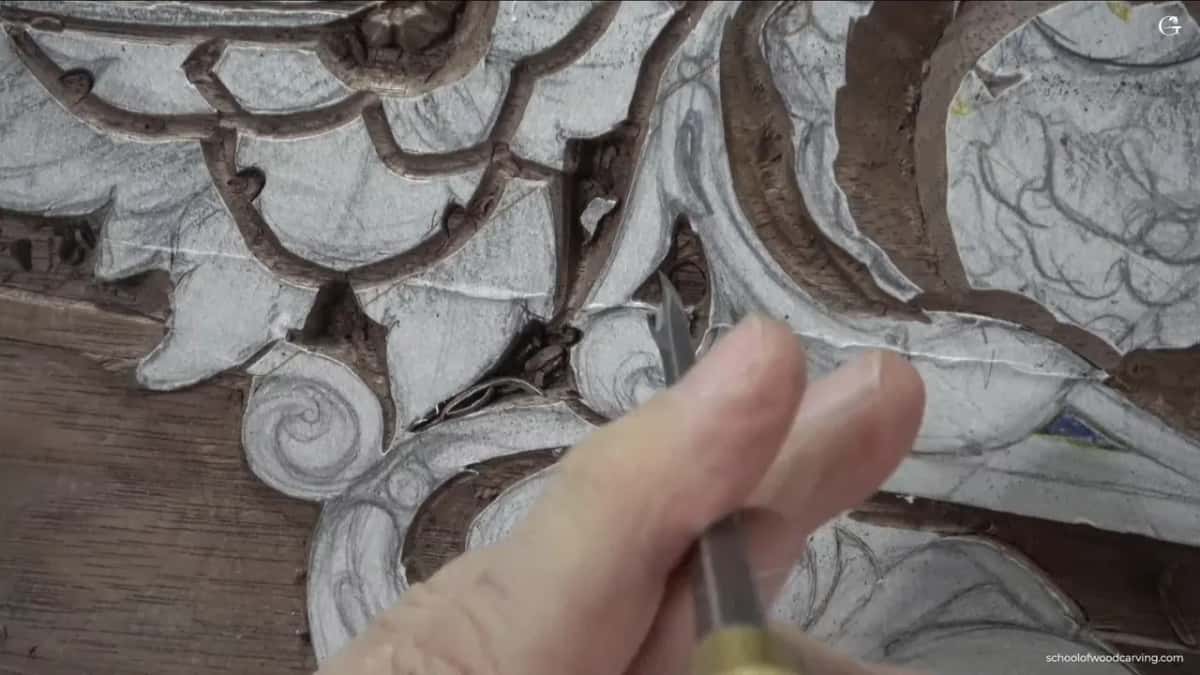Dense ornament under the gouge Fine gouge working a dense panel of scrolling ornament, chips lifting clear beside the blade