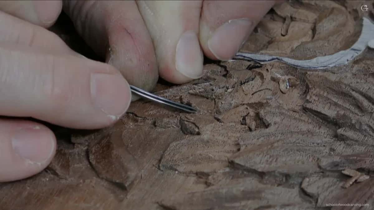 A tiny gouge easing in under a petal edge, taking the undercut just far enough to throw a dark line