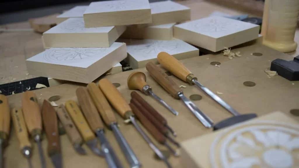 A batch of rosette blanks laid out with the gouges, which is what repeat work looks like