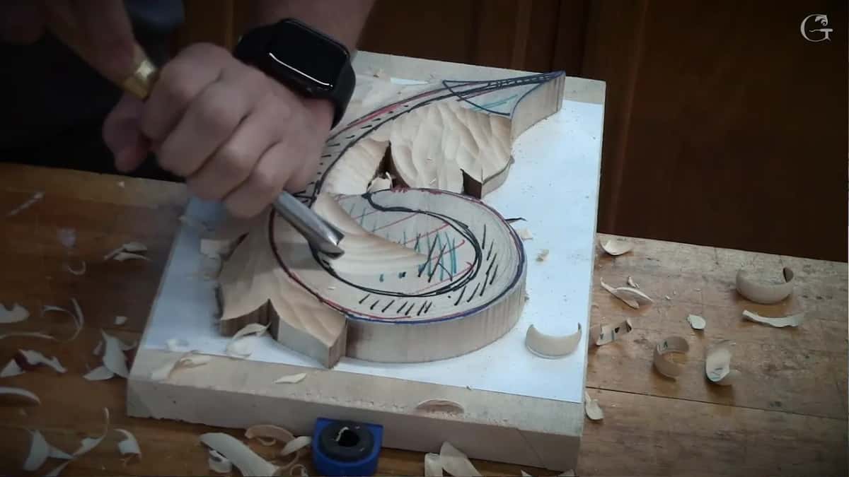 Dishing a hollow inside a black marker line with shavings scattered all around the blank