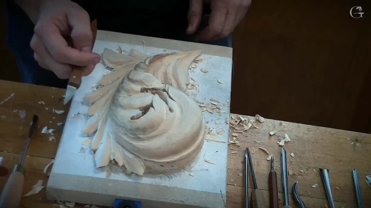 Byzantine leaf on the grey board Rounded Byzantine leaf being carved on a grey board, small tools laid out along the bottom of the frame