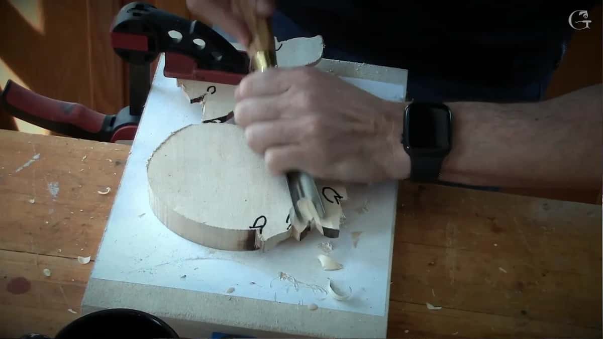 The piece clamped upside down to undercut it, a millimetre of wood left standing at the edge