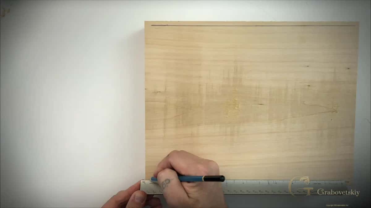One pencil line ruled across a clean dry basswood board with a steel rule and a blue pencil