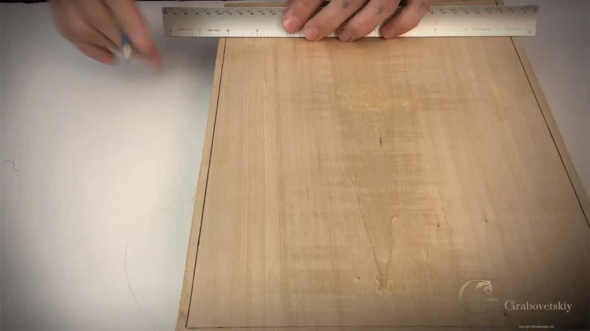 Border lines pencilled in around all four edges of a basswood board before any carving design goes on