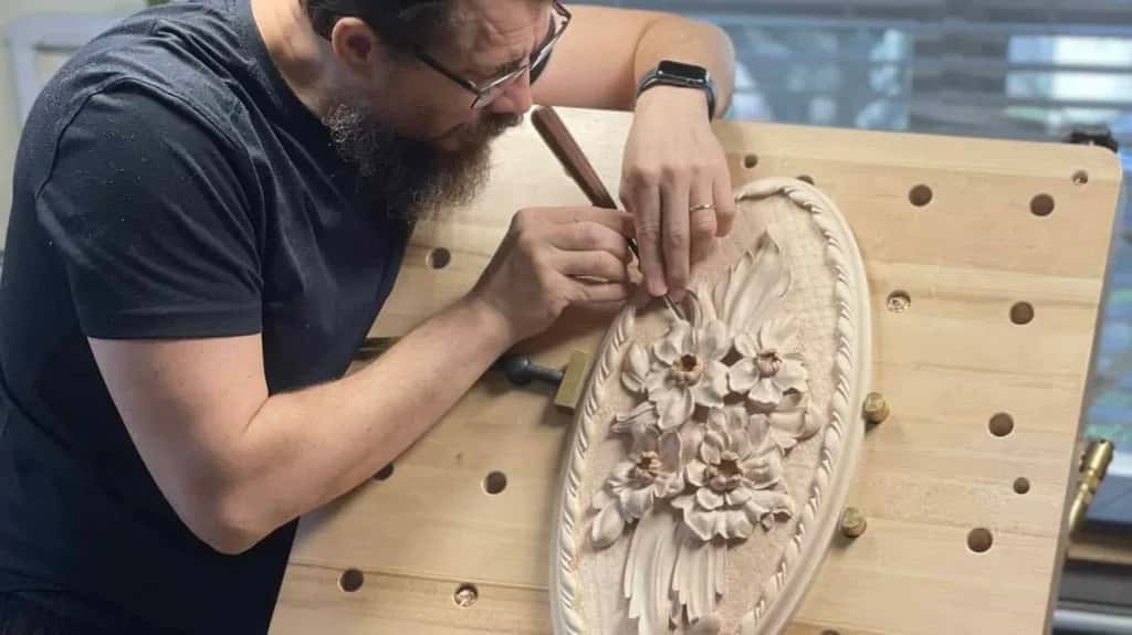 Alexander Grabovetskiy carving a Venetian rosette on a board full of dog holes