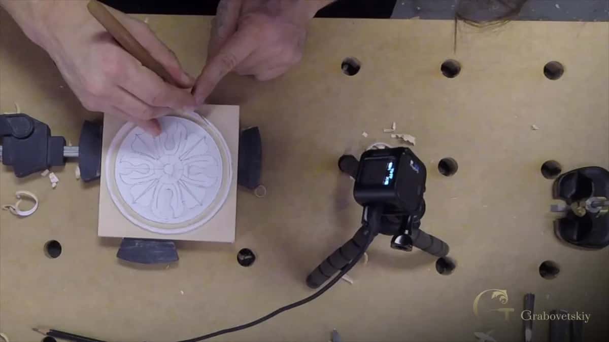 Pencil grip for fine knife work on a rosette Seen from above, the knife pinched like a pencil so it can follow the inner circle of a rosette