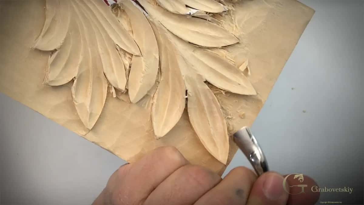 Spoon shaped back bent carving tool reaching under a carved acanthus lobe