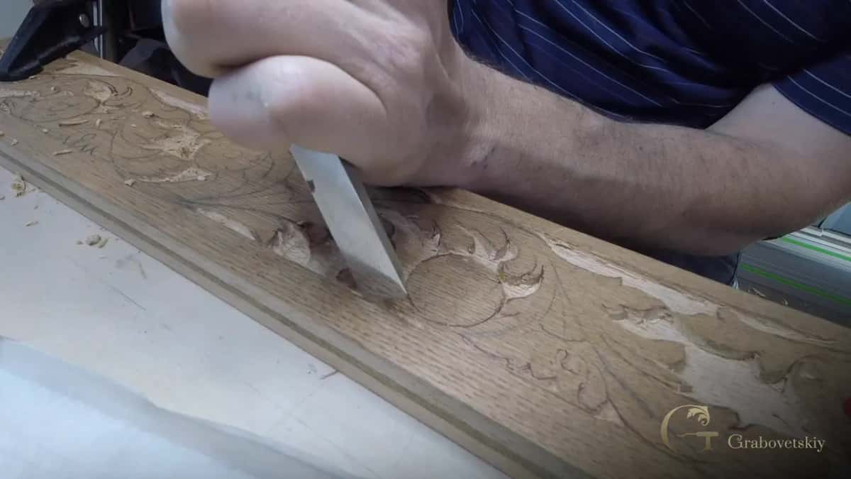 Cleaning the wall in steps Flat chisel taking the wall of a long carved rail down one step at a time, chips gathering
