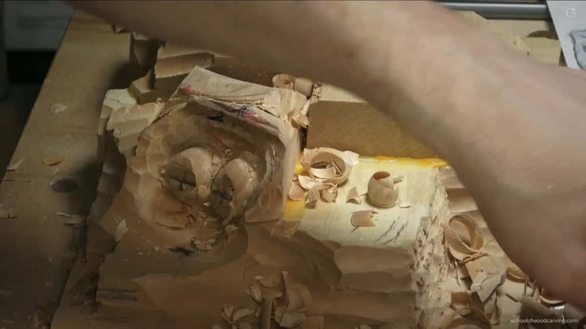 Turning the hazelnut panel sideways to check it reads as a full round, which is where 3D carving is judged
