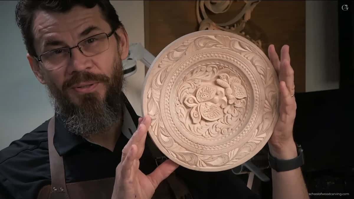 Finished carved basswood plate with two butterflies and a scalloped rim held up after the last lesson