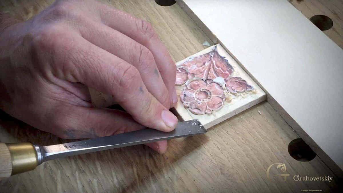 Trimming the edge of a small flower rosette with a flat chisel