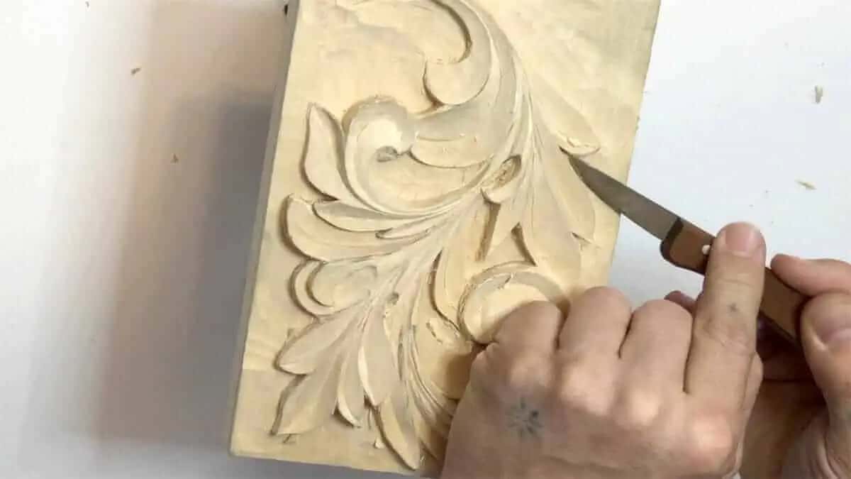 Carving knife blade cleaning the fuzz off the edge of an acanthus leaf