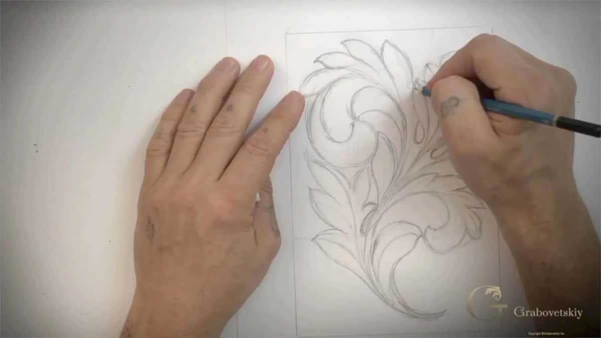Drawing the leaf before any wood is touched Two hands working an acanthus outline in pencil