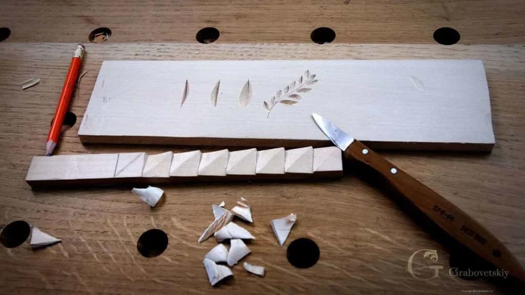 A practice board of first cuts, the knife and a scatter of chips beside it