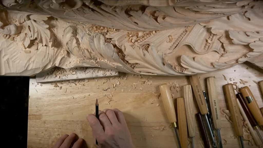 A long carved frieze with the gouges lined up on the bench below it
