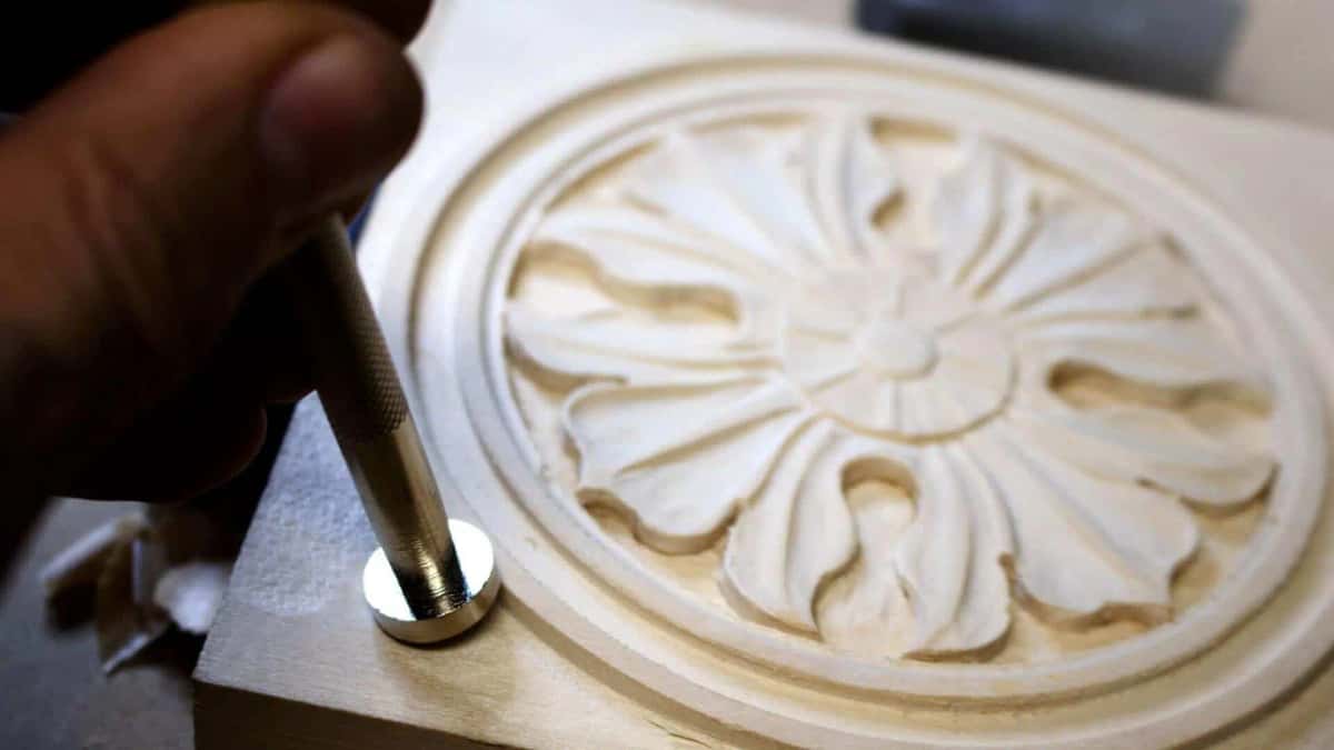 Small punch working the deep petals of a pale carved rosette, the modelling almost finished
