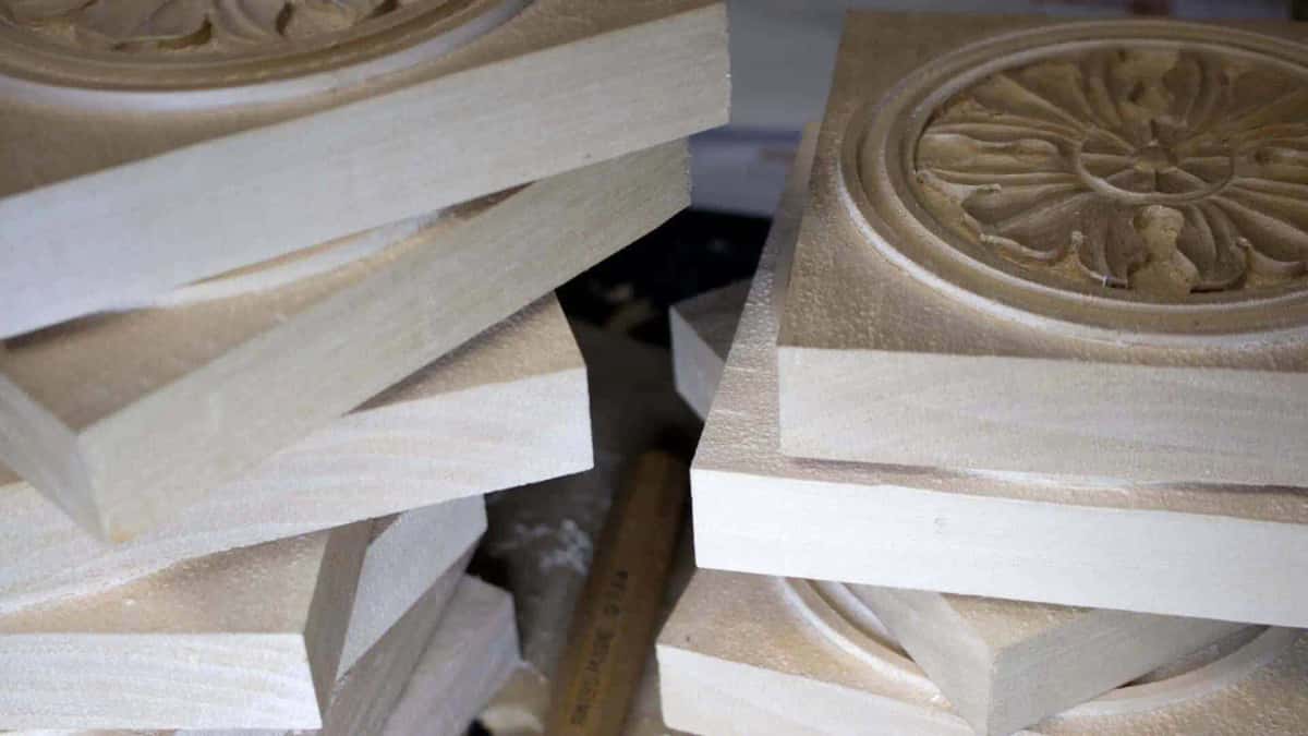 Uncarved blanks and one finished rosette standing side by side