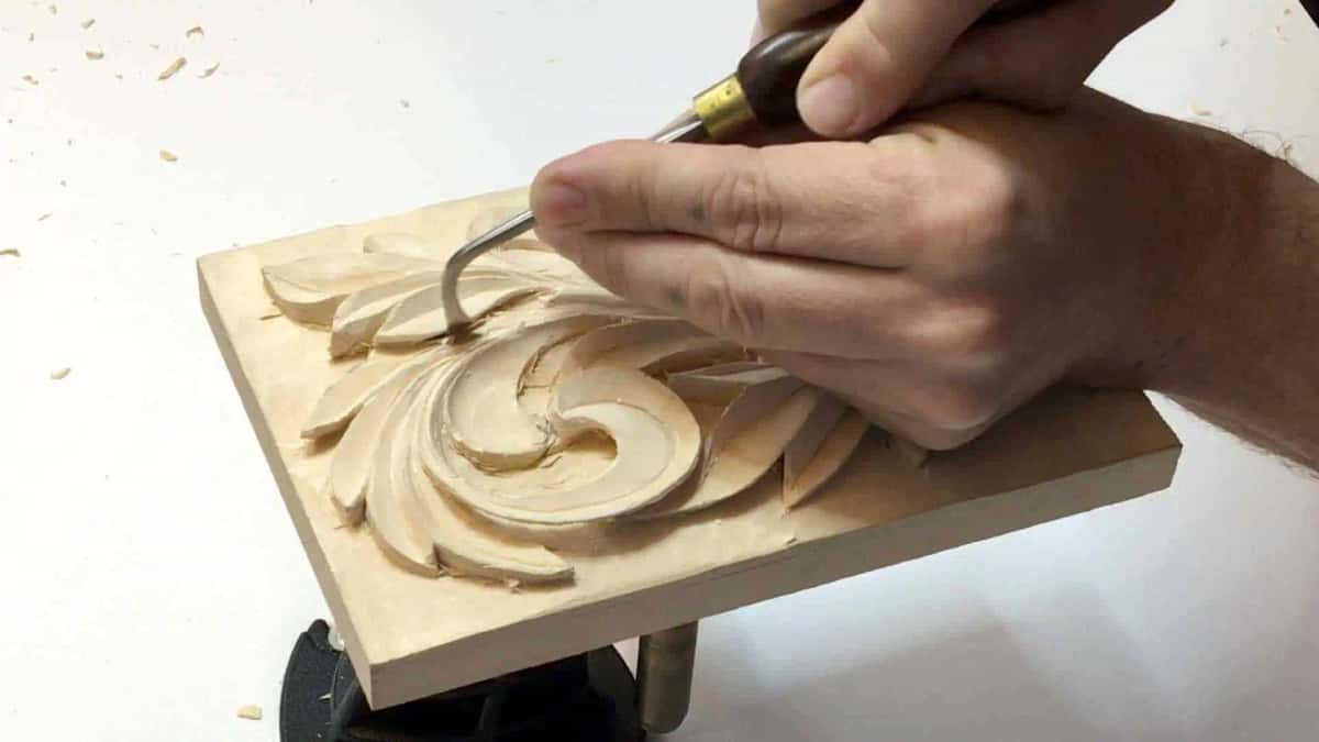 Short bent gouge with a brass ferrule reaching down into a recess in a carved acanthus rosette