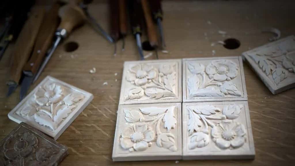 Small carved rosette tiles laid out in a row