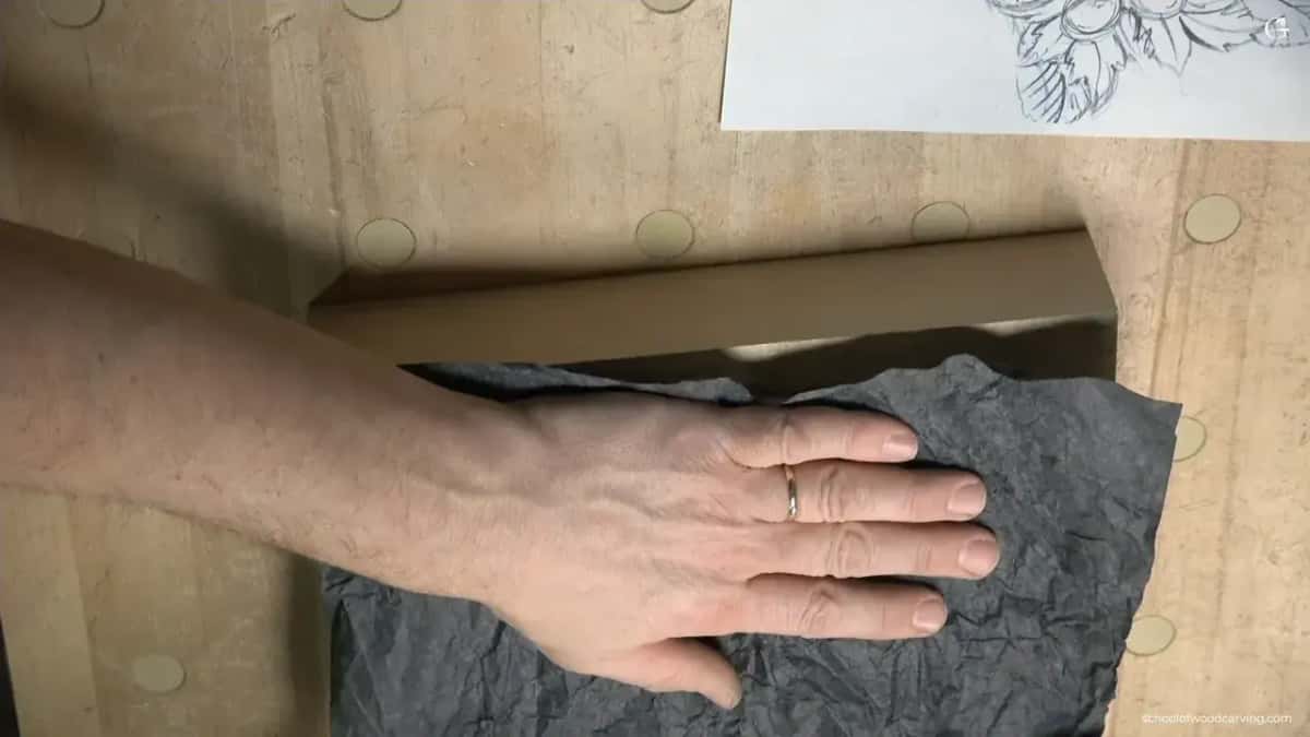 Carbon paper pressed flat onto a basswood panel with the drawing above it
