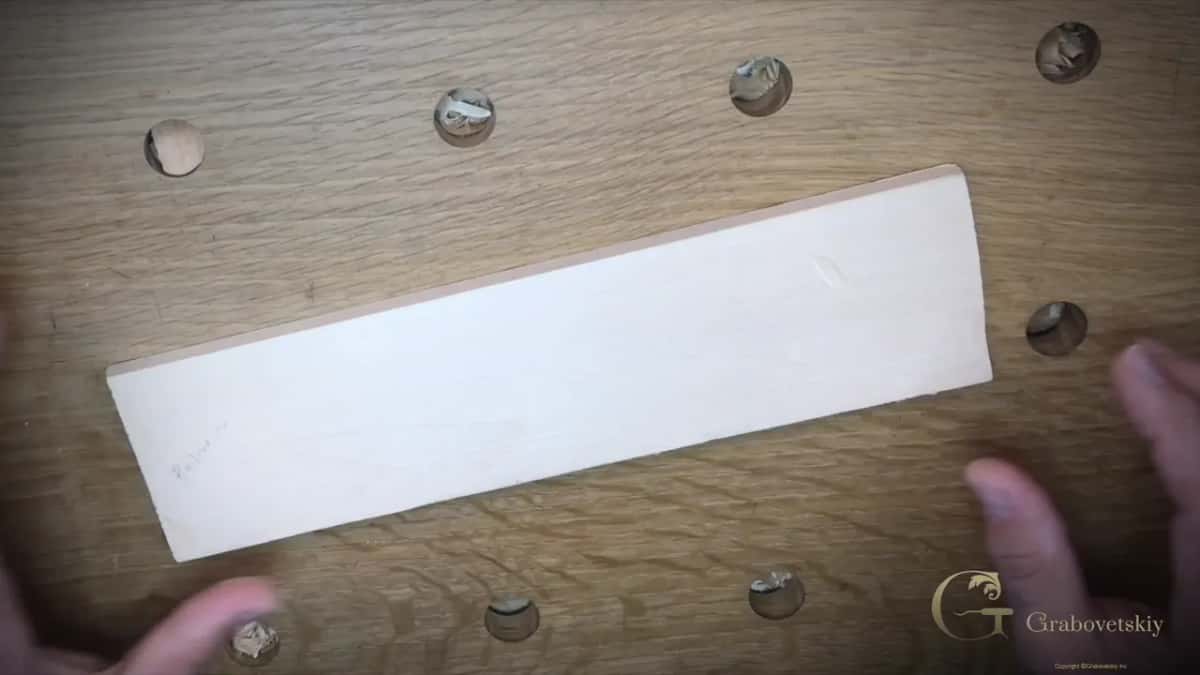 Plain basswood plank lying on the oak bench before a single line is drawn on it