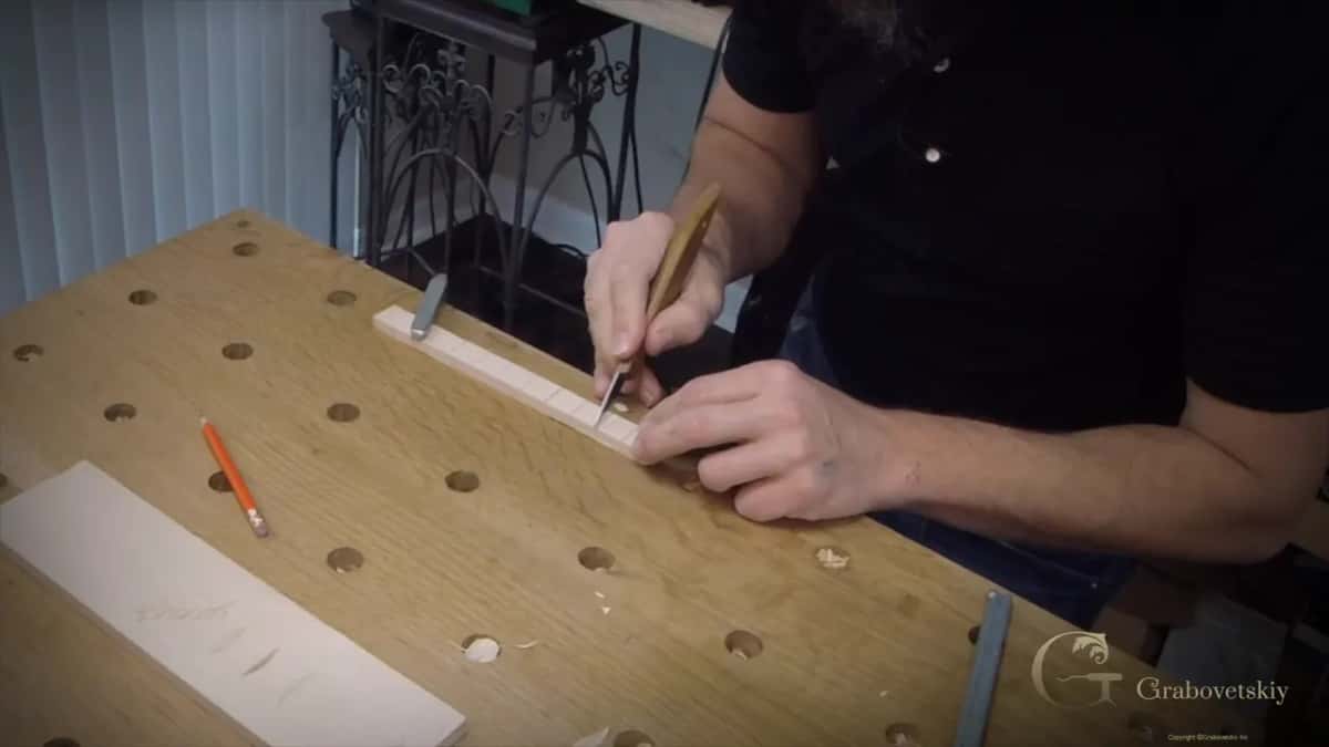 Narrow basswood strip clamped down and divided into equal spaces for the molding
