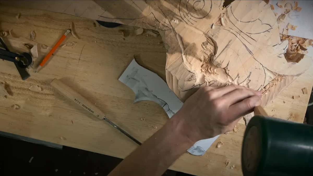Green mallet in the foreground, the gouge set against the wood