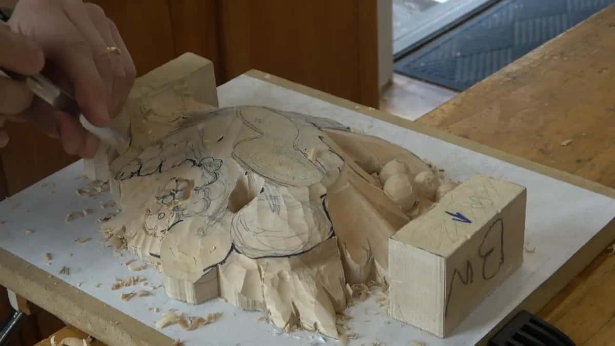 Tool working the outer edge of the panel, shavings piled along the board