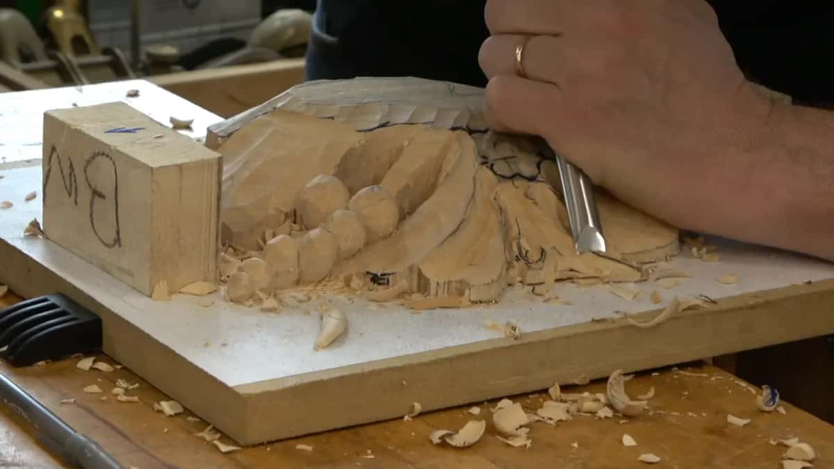 Flat chisel turned over and laid at an angle across the modelled leaf