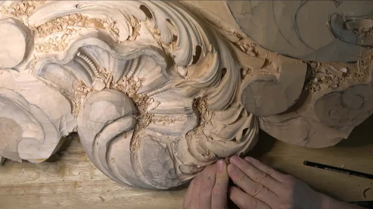 Fingertips feel the right lobe while a pencil waits on the bench.