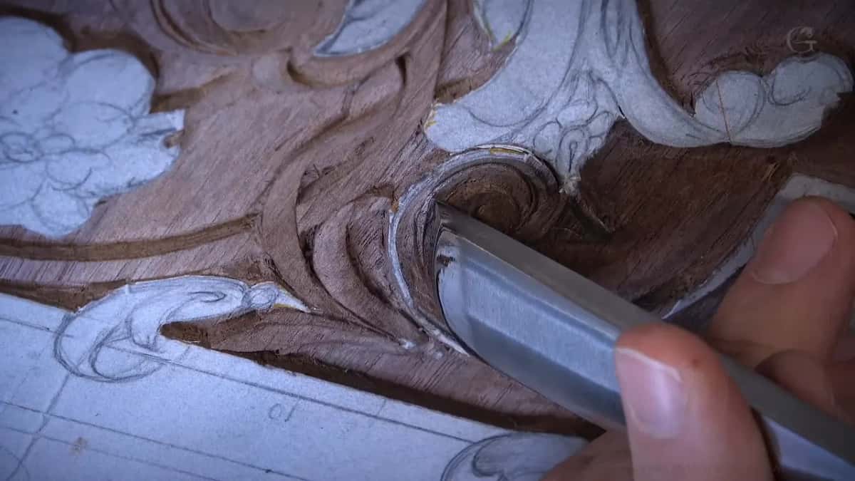 Wide bright gouge laid into a small curved line, held between finger and thumb at the right of the frame