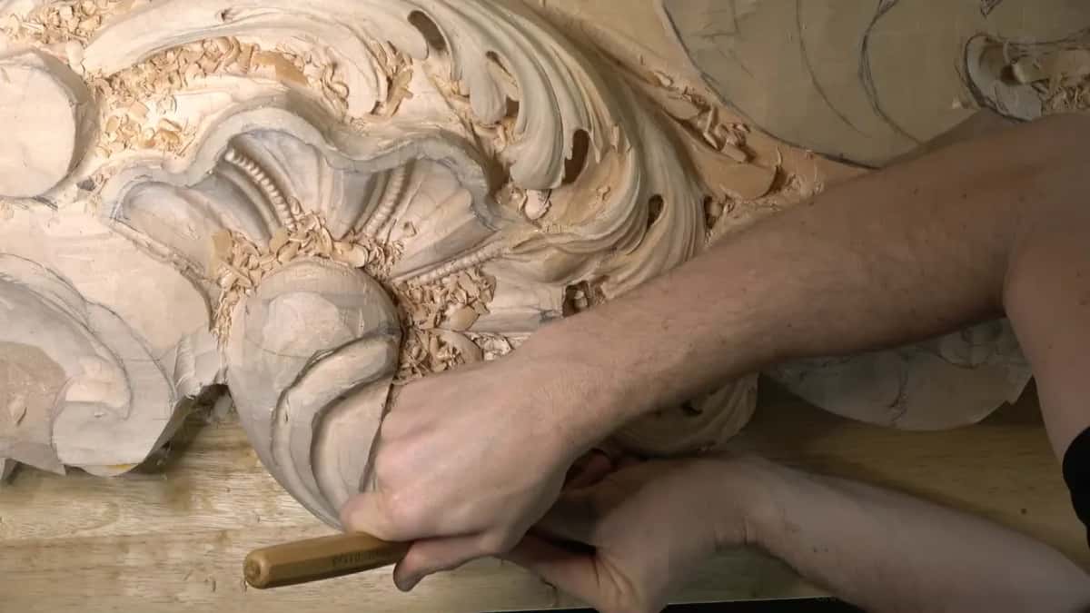 Arms across the panel, the blade set into the lower hollow.